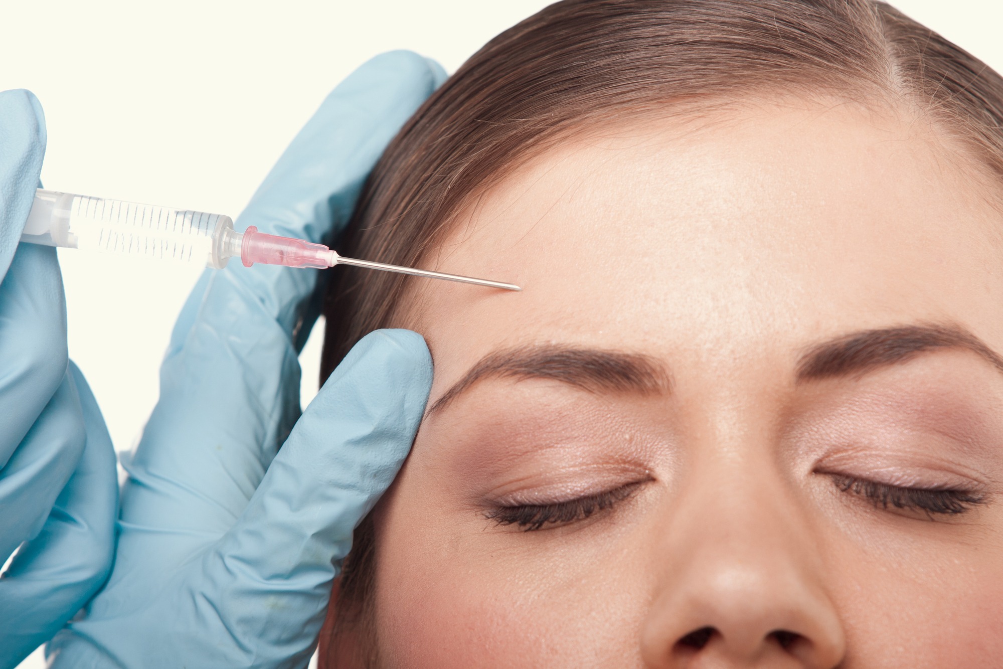 model on white background having botox injection