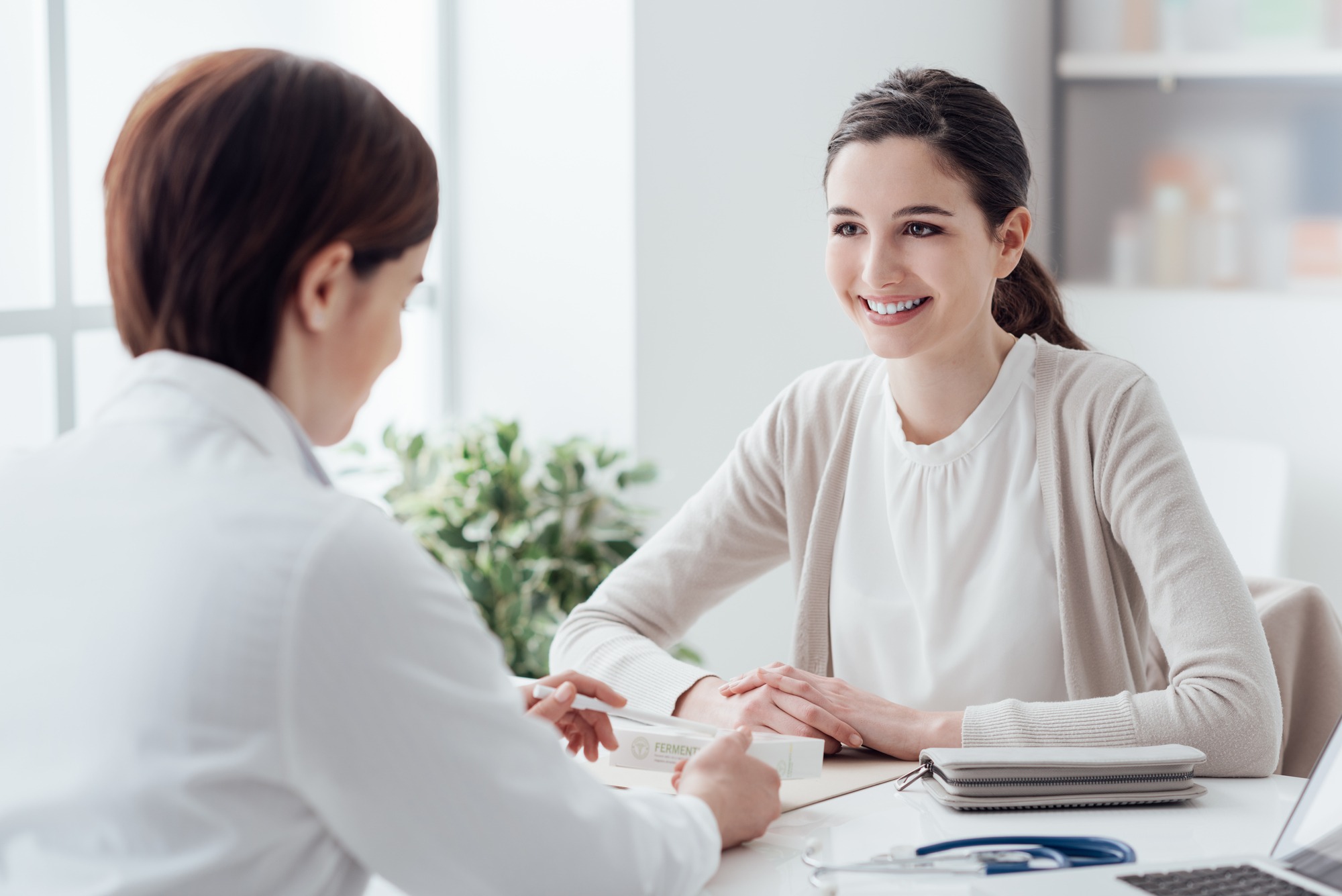Smiling patient in the doctor's office, she is receiving a prescription medicine
